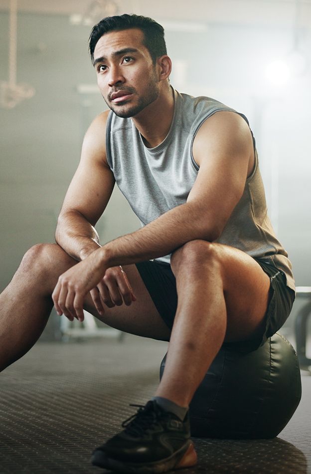 Man resting on a gym ball, thinking.