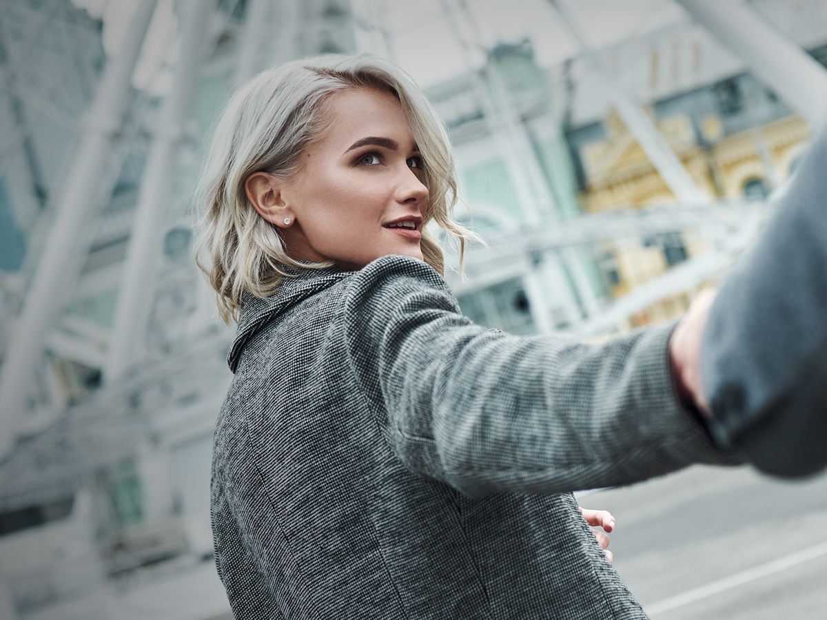 Woman looking back while holding someone's hand.