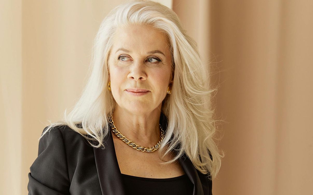 Woman with long blonde hair and elegant attire.